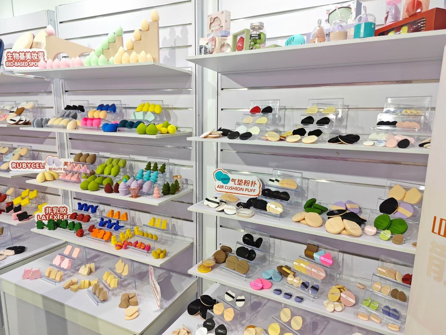 Display shelves filled with various colorful makeup sponges and puffs in different shapes and sizes.